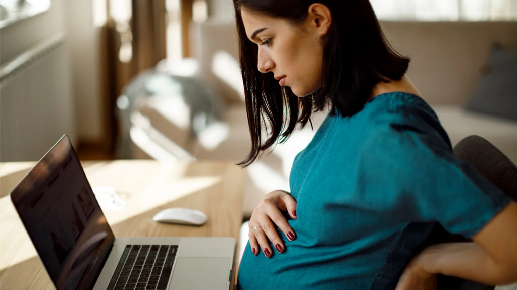 donna al pc sperimenta i primi sintomi di gravidanza