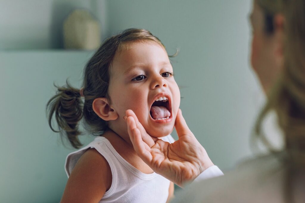 bambina con mal di gola, uno dei potenziali sintomi della mononucleosi