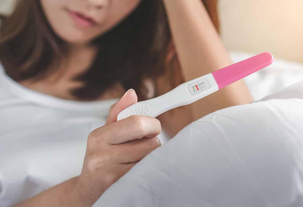 donna utilizza un test di ovulazione per calcolare il periodo di fertilità